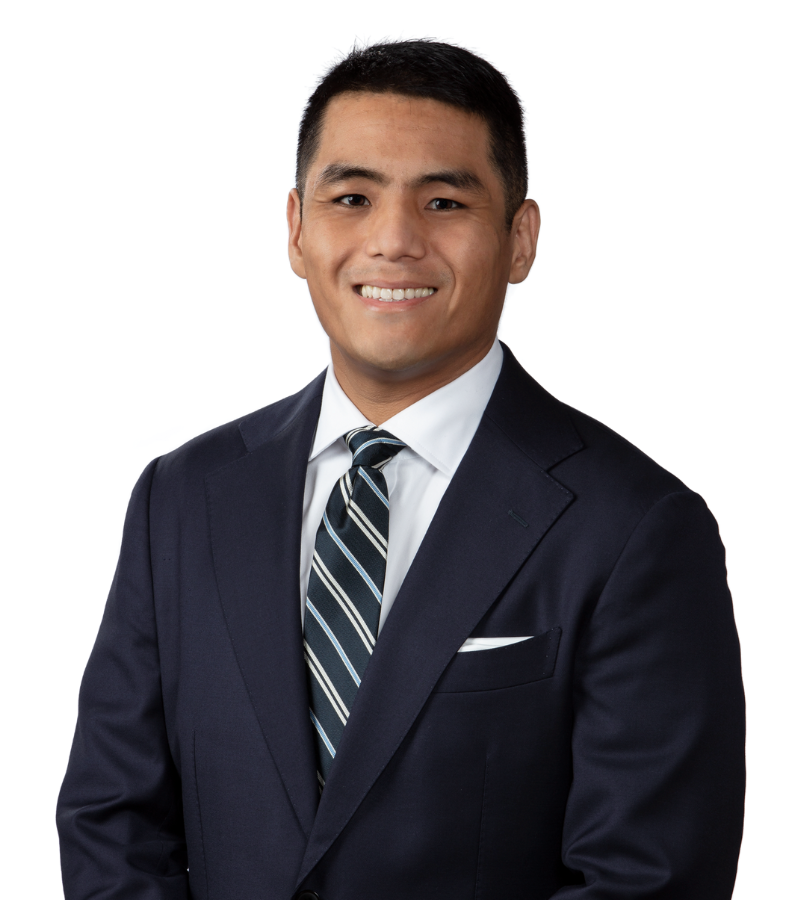 Photo of attorney Tenzing Tunden in a dark business suit with white jacket and striped black and white tie